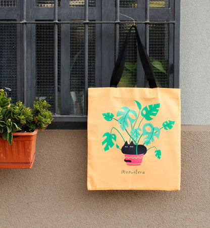 Tote bag in canvas di cotone stampato - Meowstera, un paffuto gatto nero seduto su una pianta di Monstera